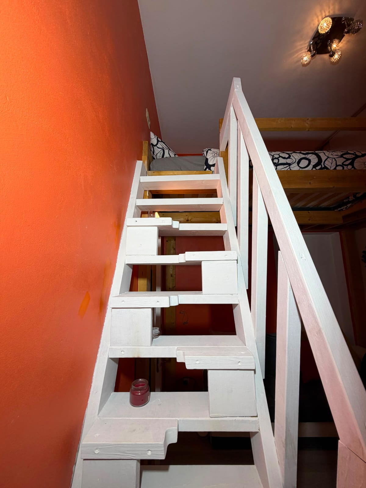 Escalier blanc menant à la mezzanine du logement
