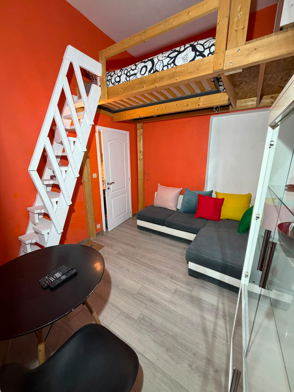 Salon avec canapé sous une mezzanine en bois