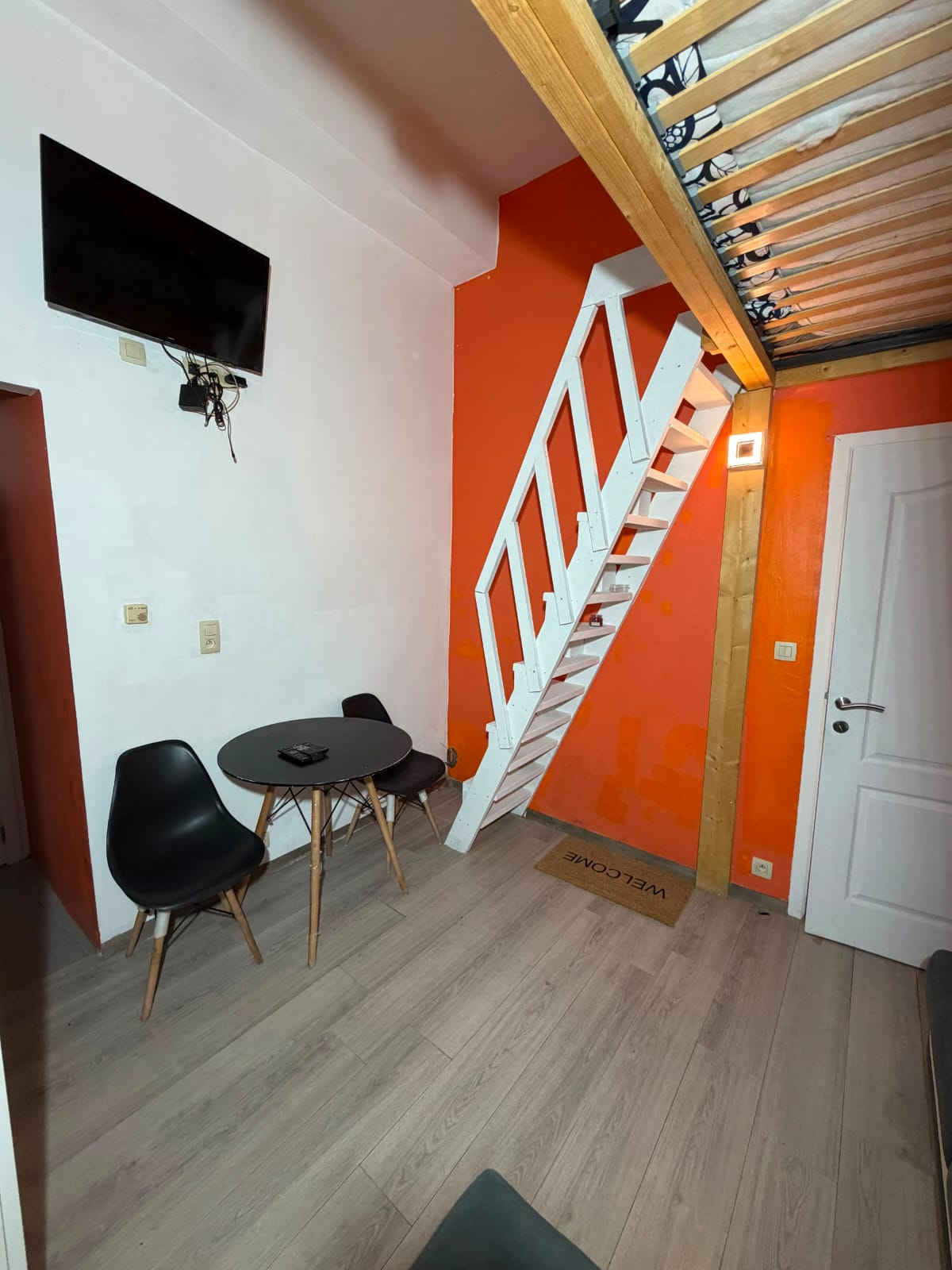 Coin repas avec table, chaises, télévision et escalier
