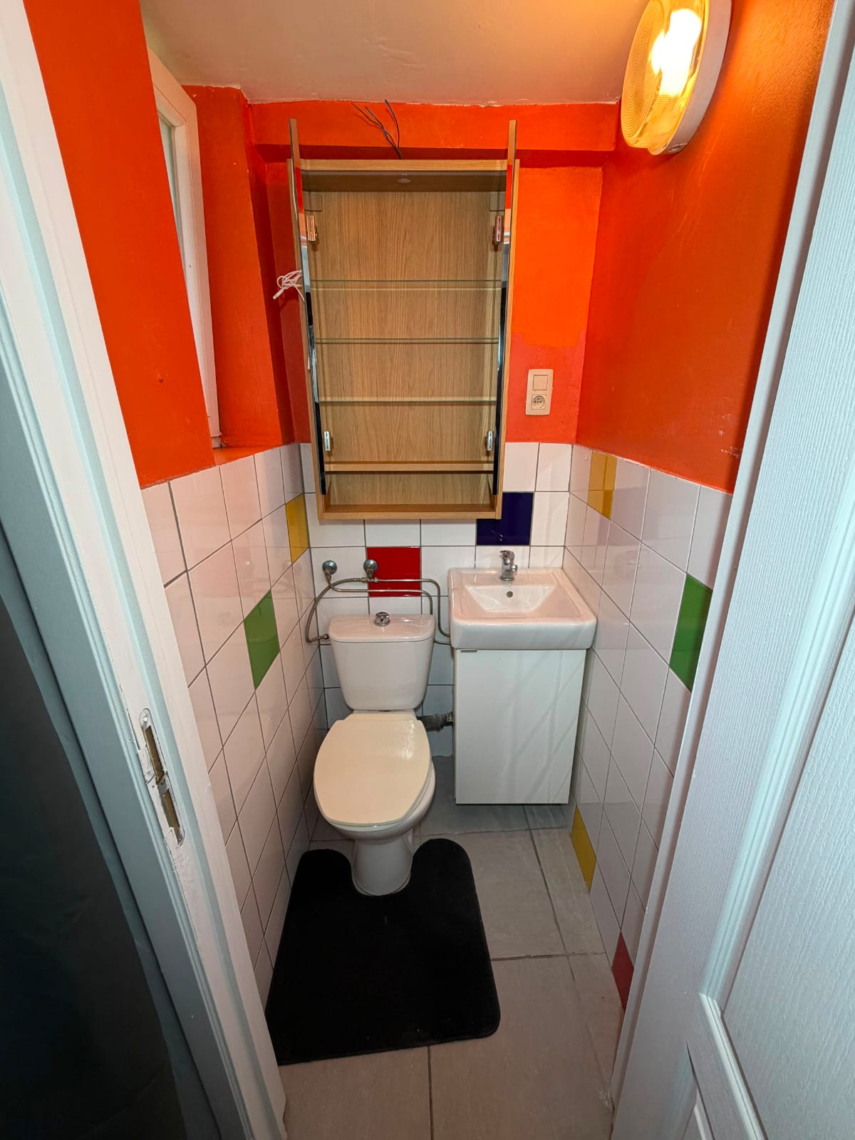Toilettes séparées dans une pièce aux tons orange