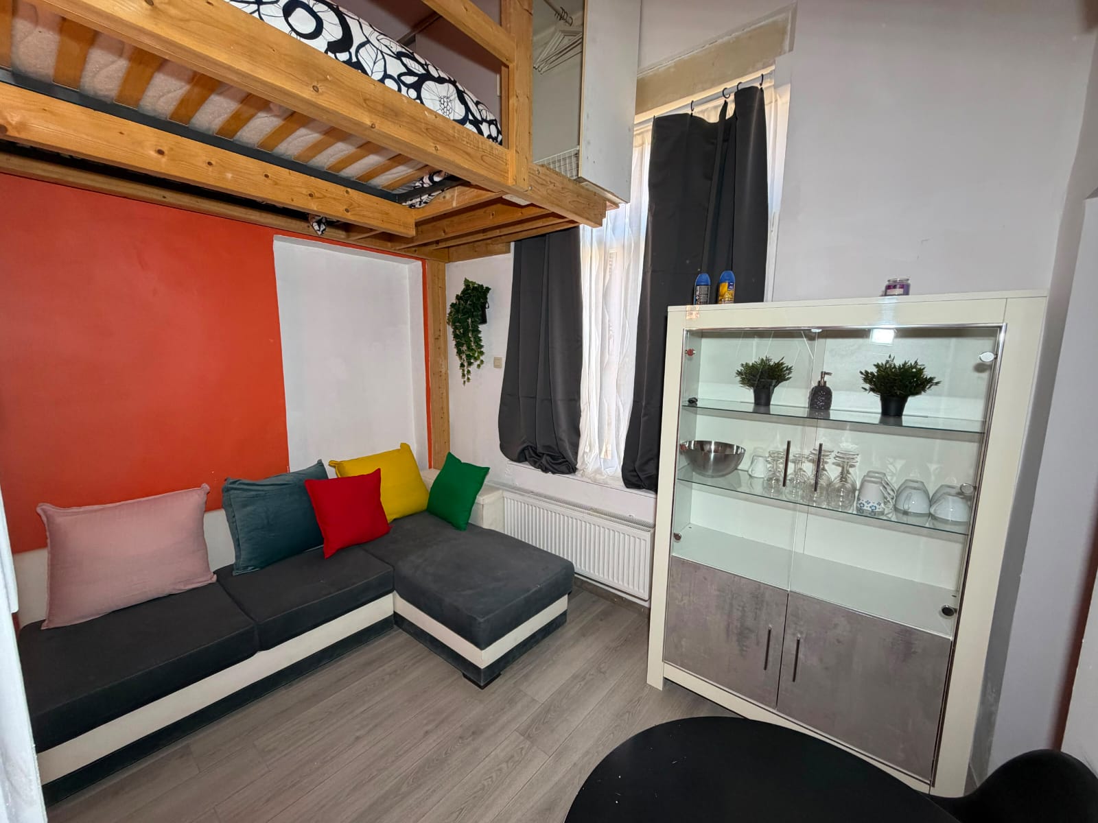 Salon chaleureux avec canapé d’angle et meuble vitré