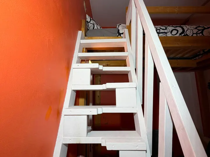 Escalier blanc menant à la mezzanine du logement
