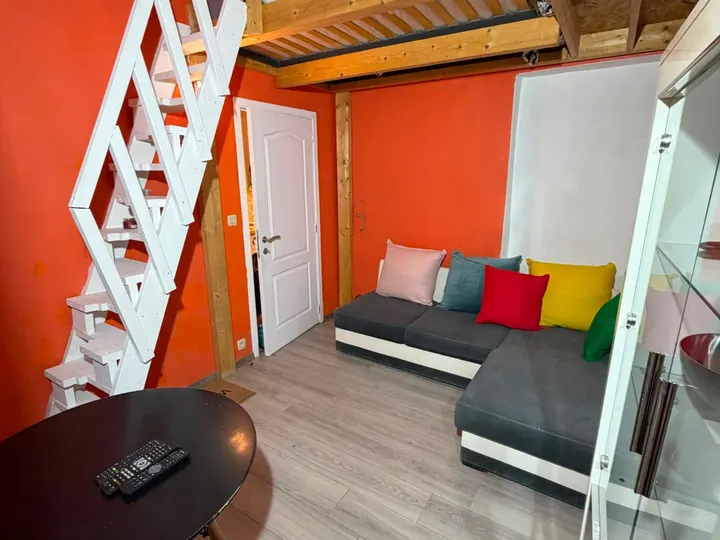 Salon avec canapé sous une mezzanine en bois