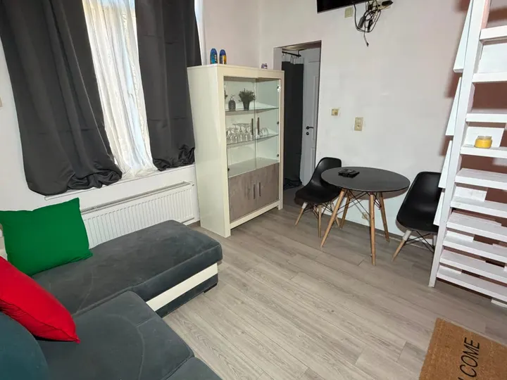 Séjour lumineux avec canapé, rangement et coin repas