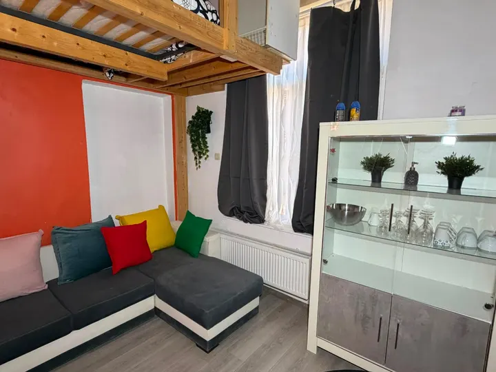Salon chaleureux avec canapé d’angle et meuble vitré
